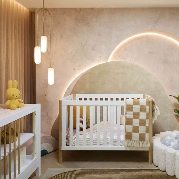 Modern nursery room with a crib, changing table, and decorative elements. As seen on The Block.